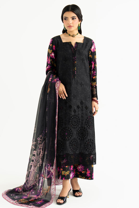 Woman wearing a black embroidered dress with floral patterns on a white background