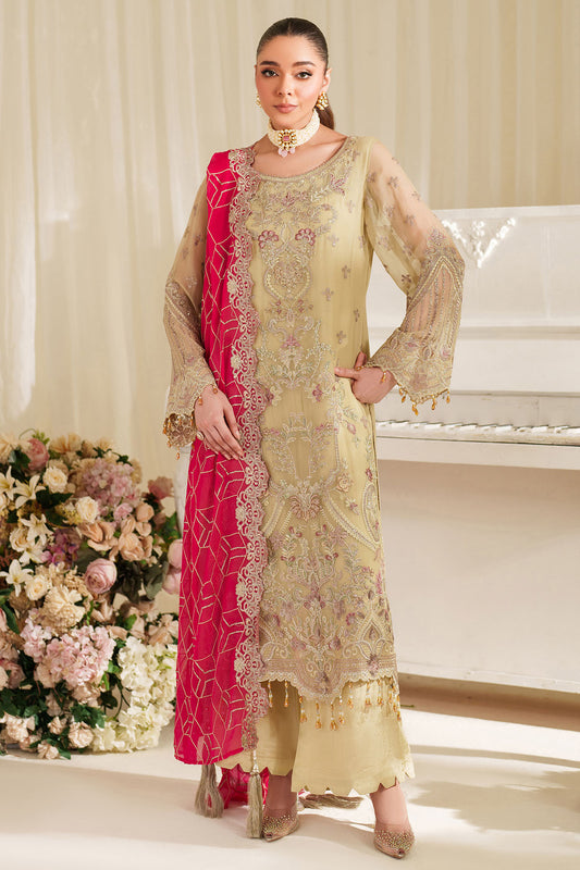 Woman in a traditional outfit with a pink dupatta standing in a decorated room.