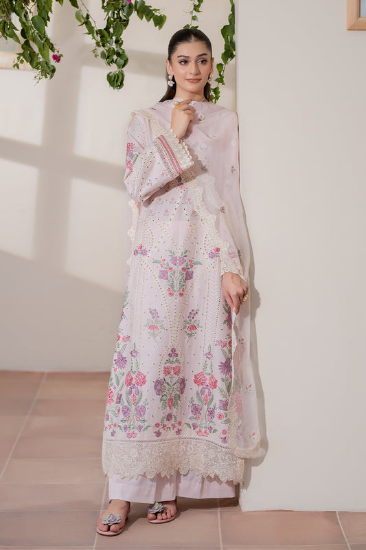 Woman wearing a white embroidered traditional outfit with a floral design indoors.