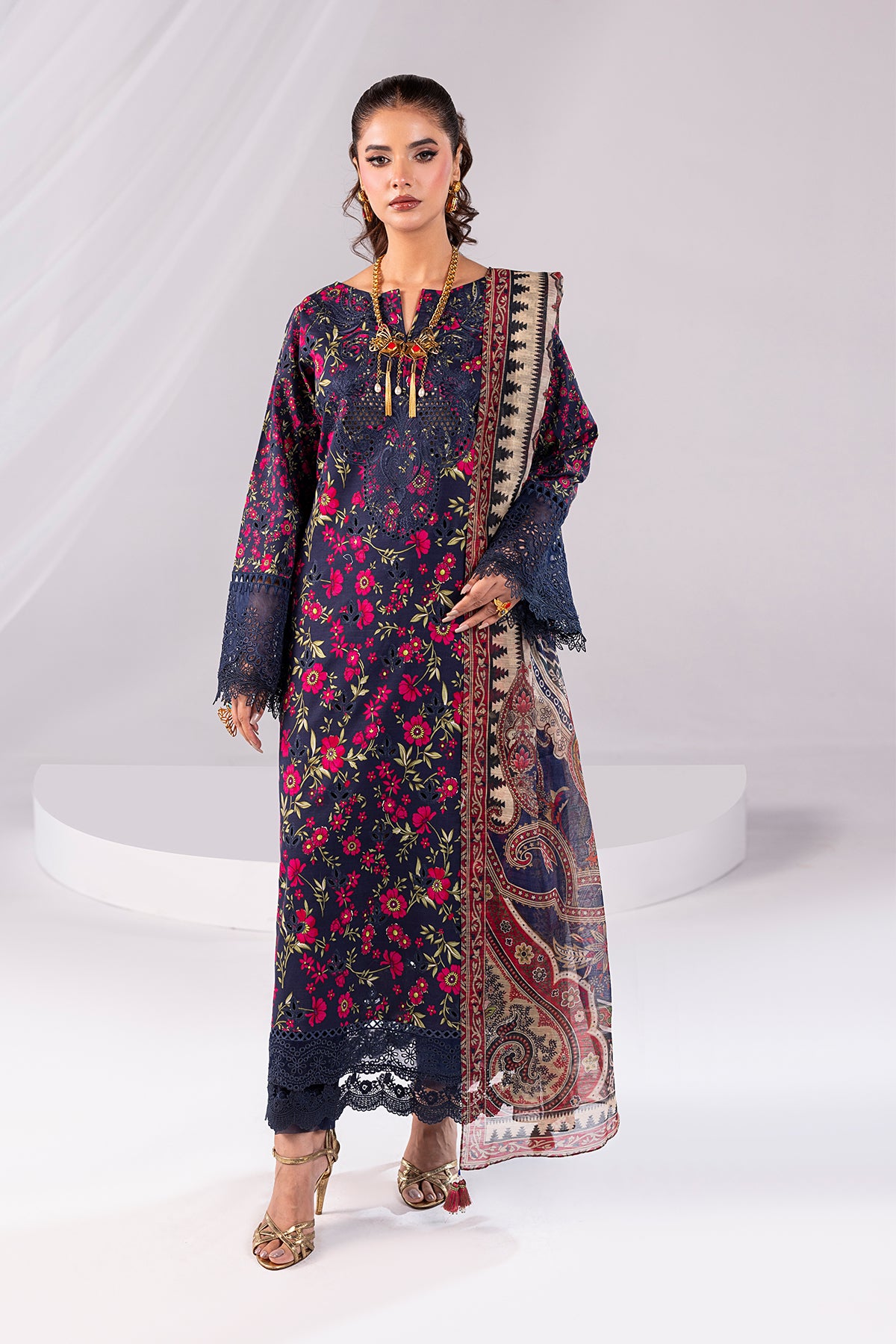Woman wearing a floral dress with a patterned shawl on a white background
